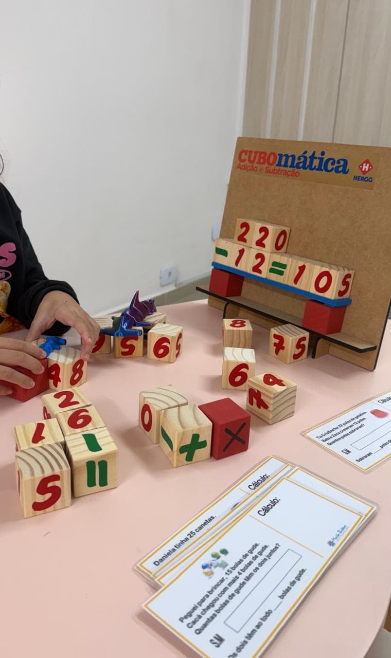 Criança em atividade de matemática com blocos numéricos